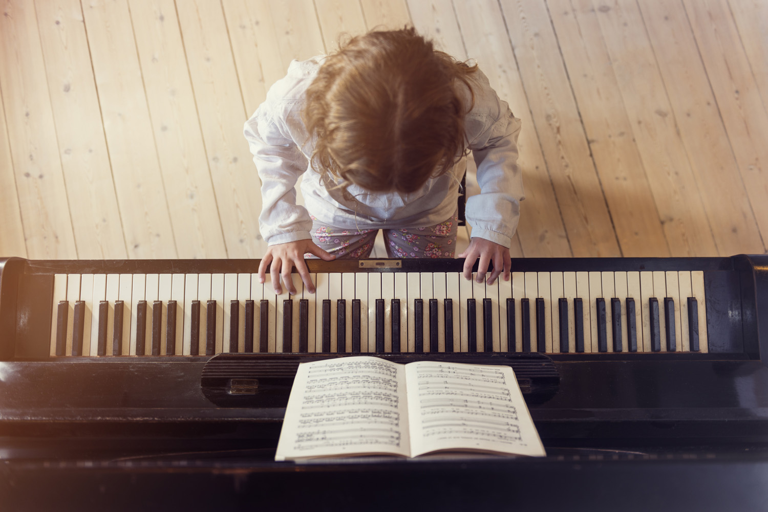 Photo of a child conscientiously practising the piano at home