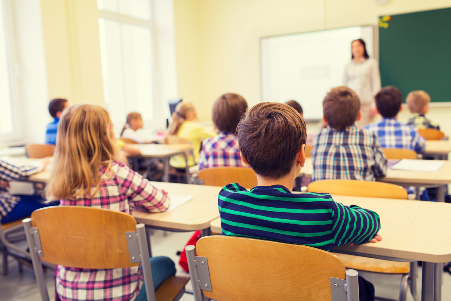 Photo of a class of children listening to their teacher in school