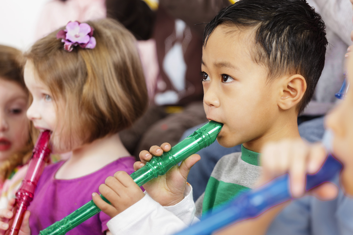 Photo of young children playing colourful recorders
