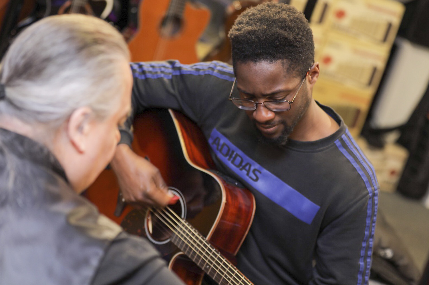 Photo of a guitar teacher giving a lesson at the Yamaha Music store