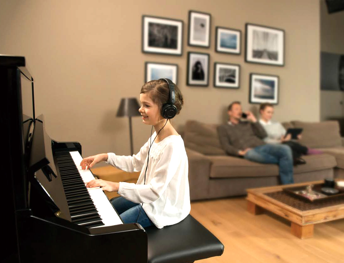 Yamaha Silent piano being played by a girl whilst her mother is on the phone and her dad uses an iPad