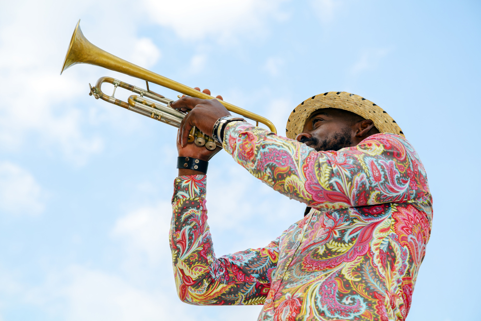 Man playing the trumpet against a clear sky in Cuba