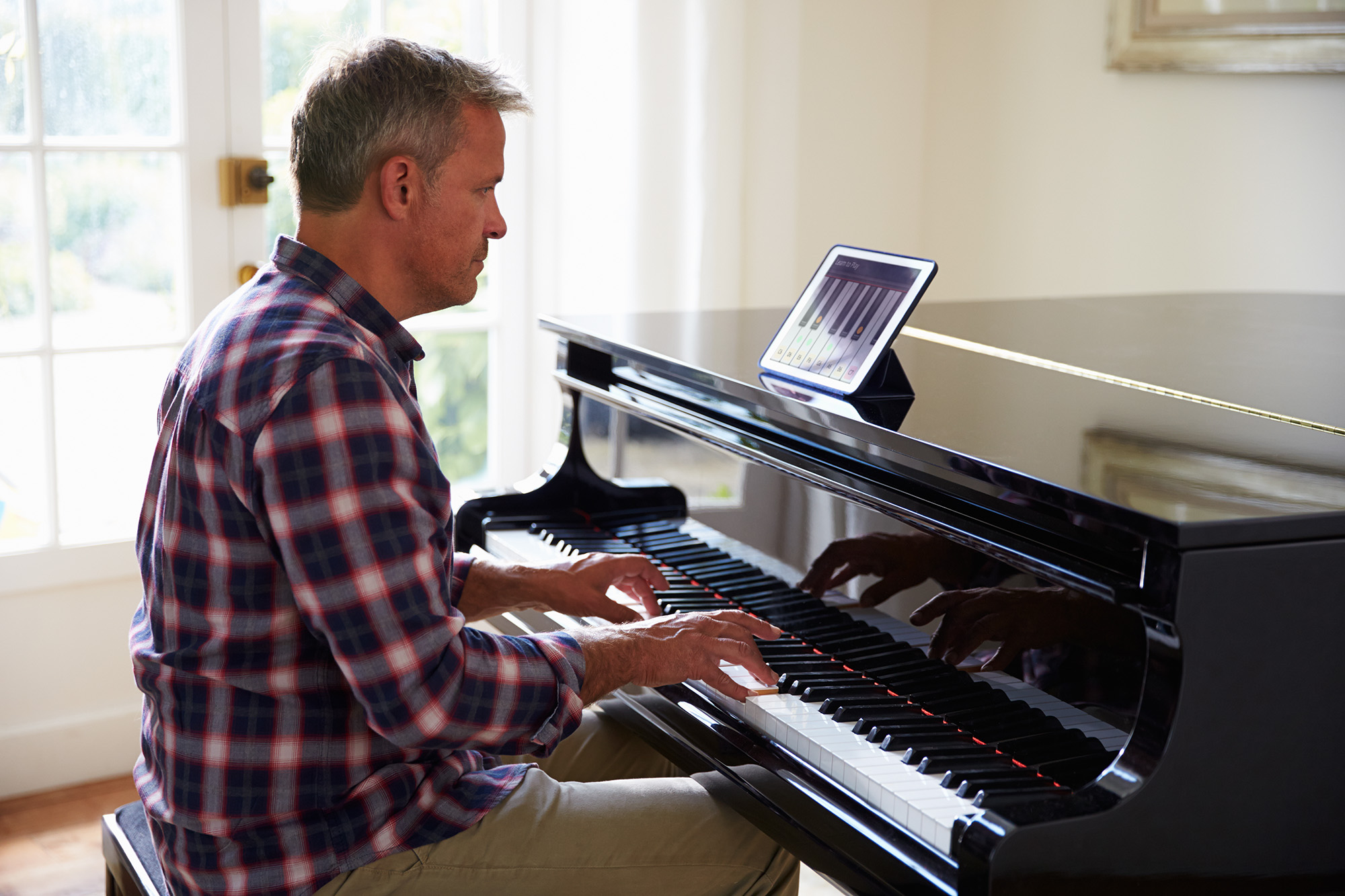 A father learning the piano using an app