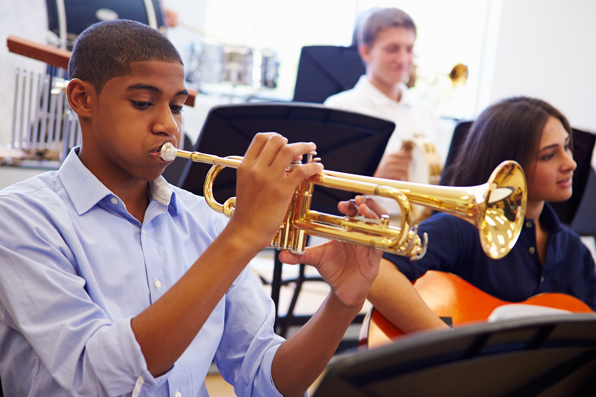 A boy playing the trumpet in a school