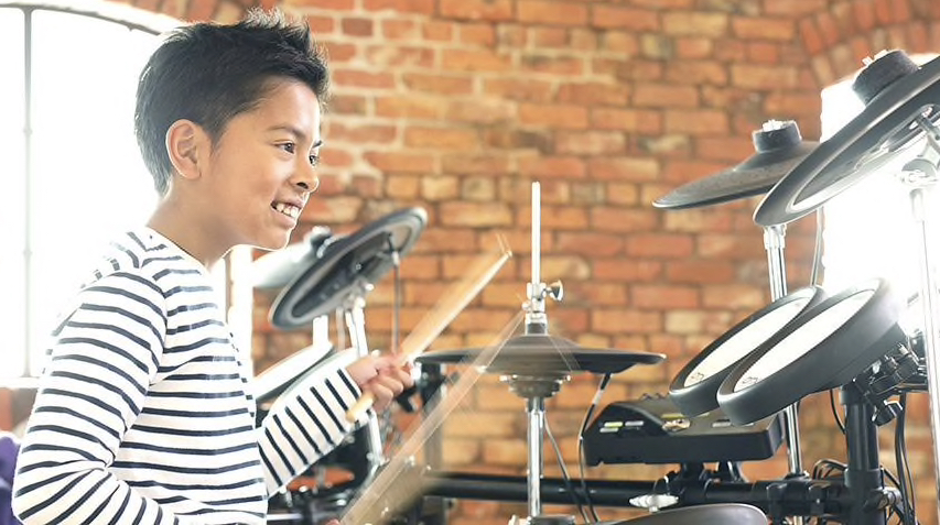 Child learning to play drums