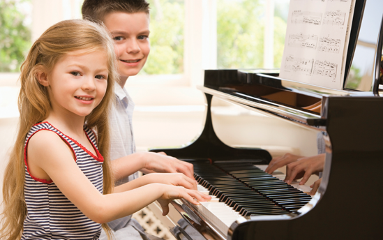 Children playing a Yamaha piano